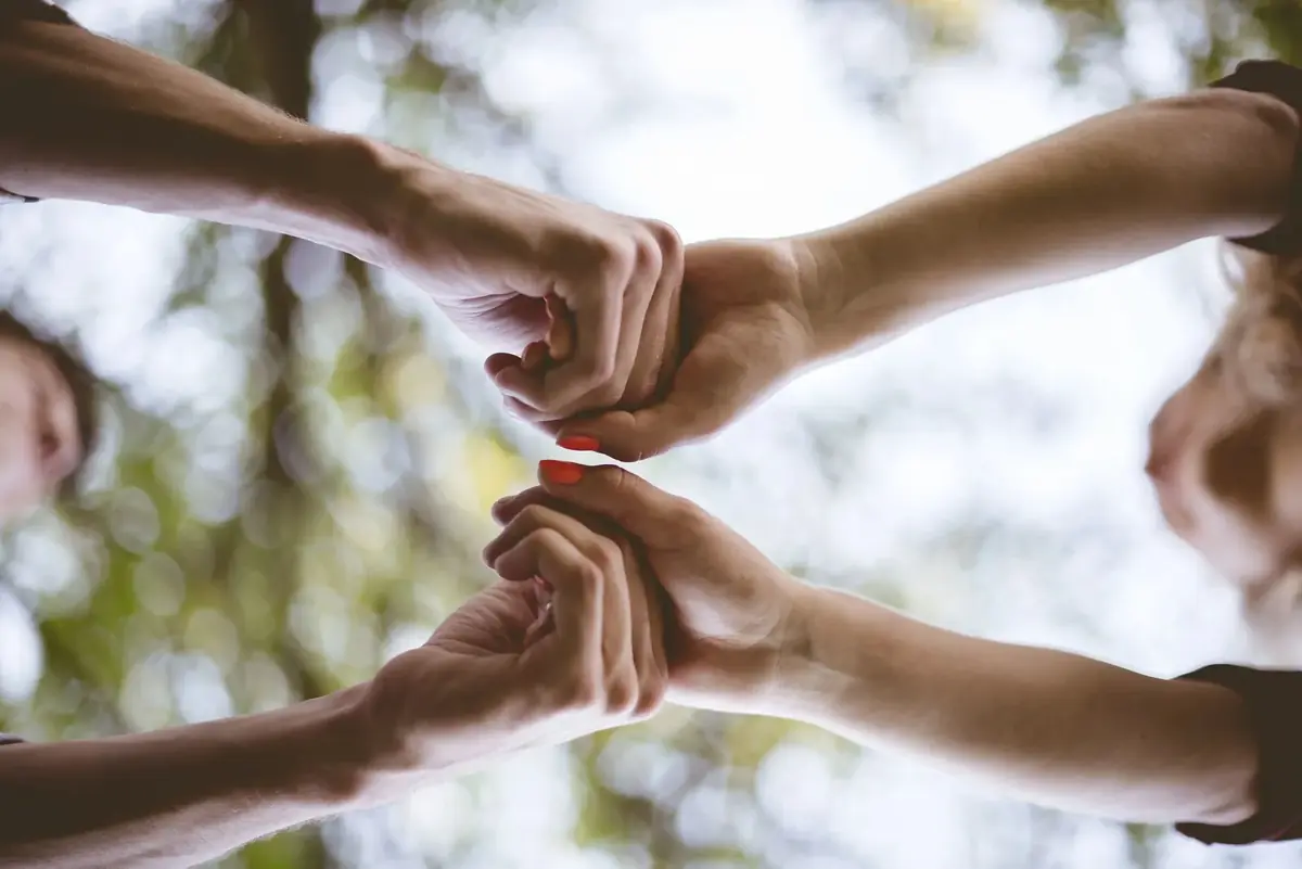 Grupo de personas cogidas de las manos en unión y apoyo mutuo